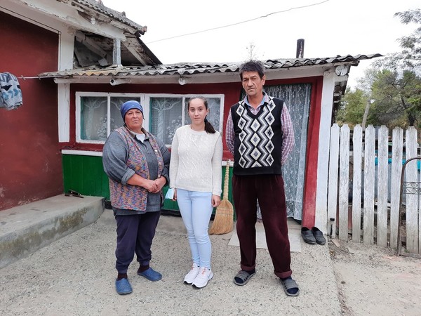 Andra and her parents in front of their house