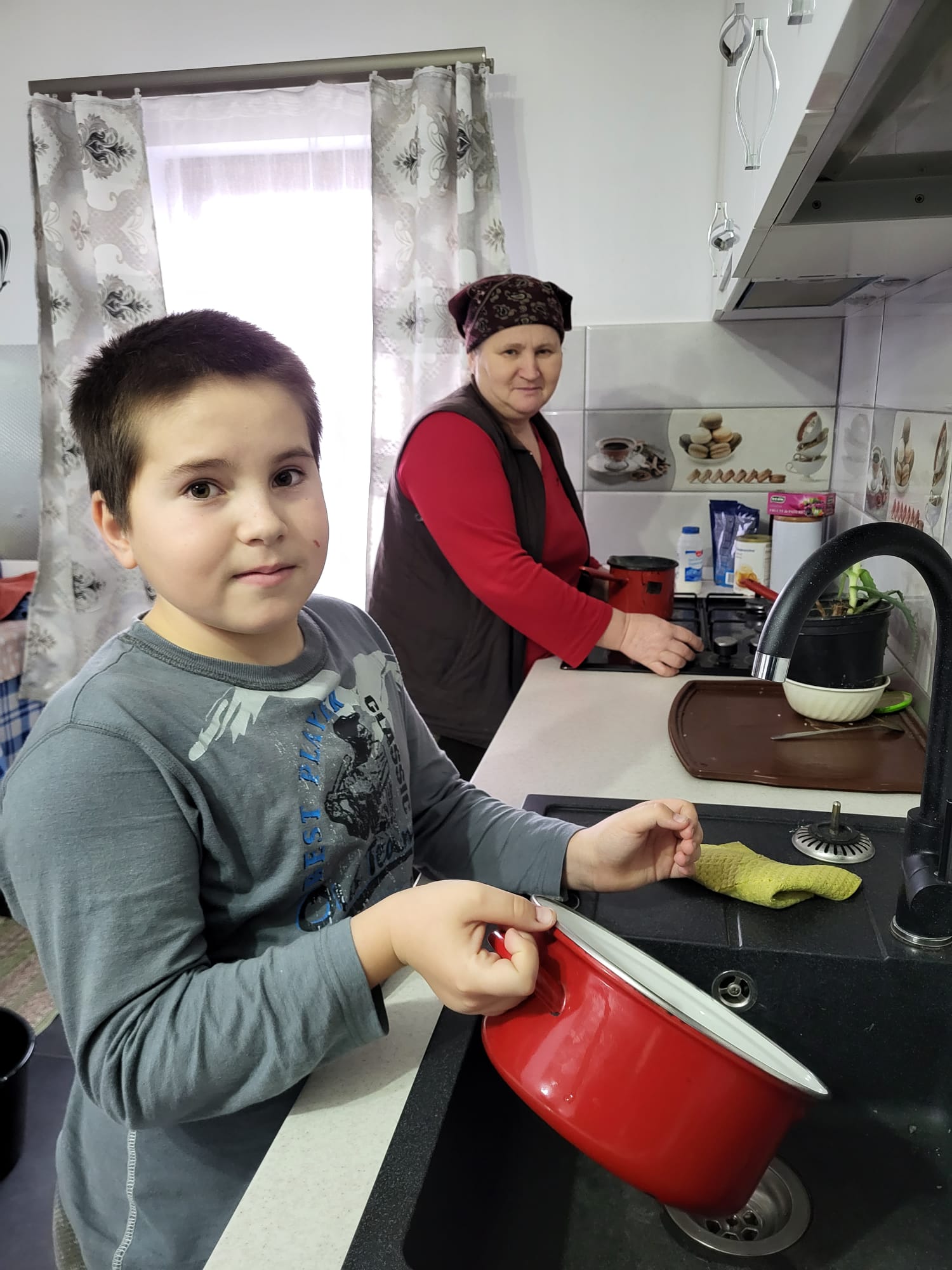 Ionut helps his grandmother with the dishes at home