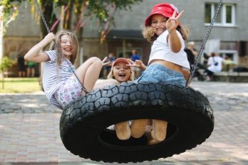Friends enjoying a tire swing at a special summer camp in Ukraine